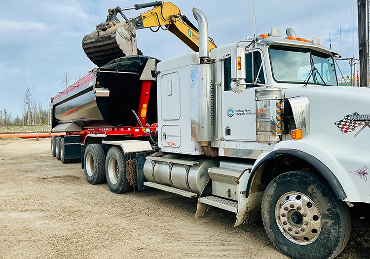 Excavator filling dump truck