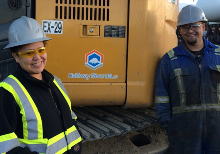 Workers in front of Halfway River IDL LP branded excavator