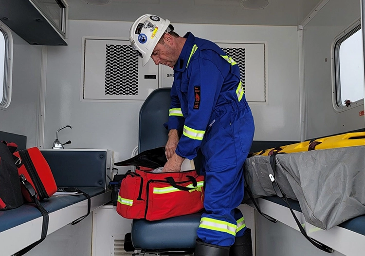 Man in coveralls inside mobile first aid unit