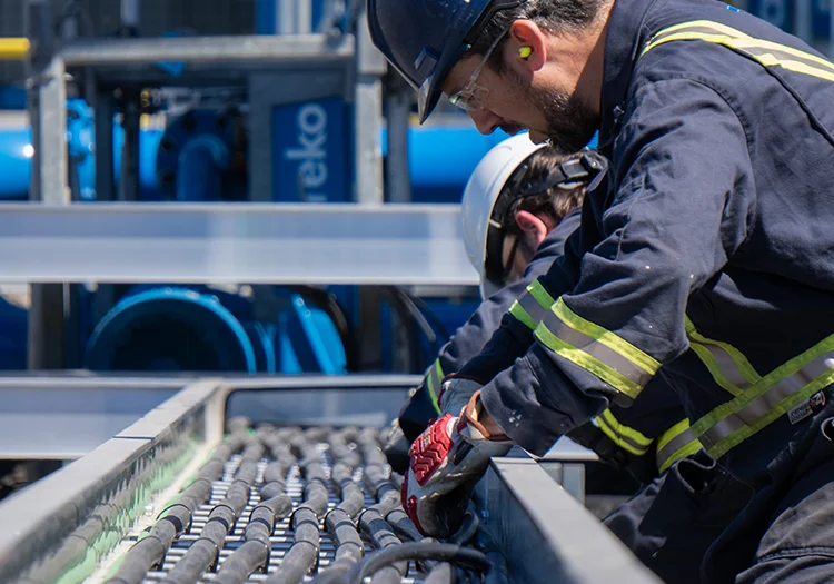 Worker in coveralls inspecting cables