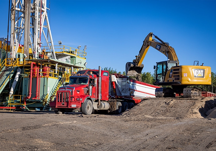 Excavator loading trailer with dirt