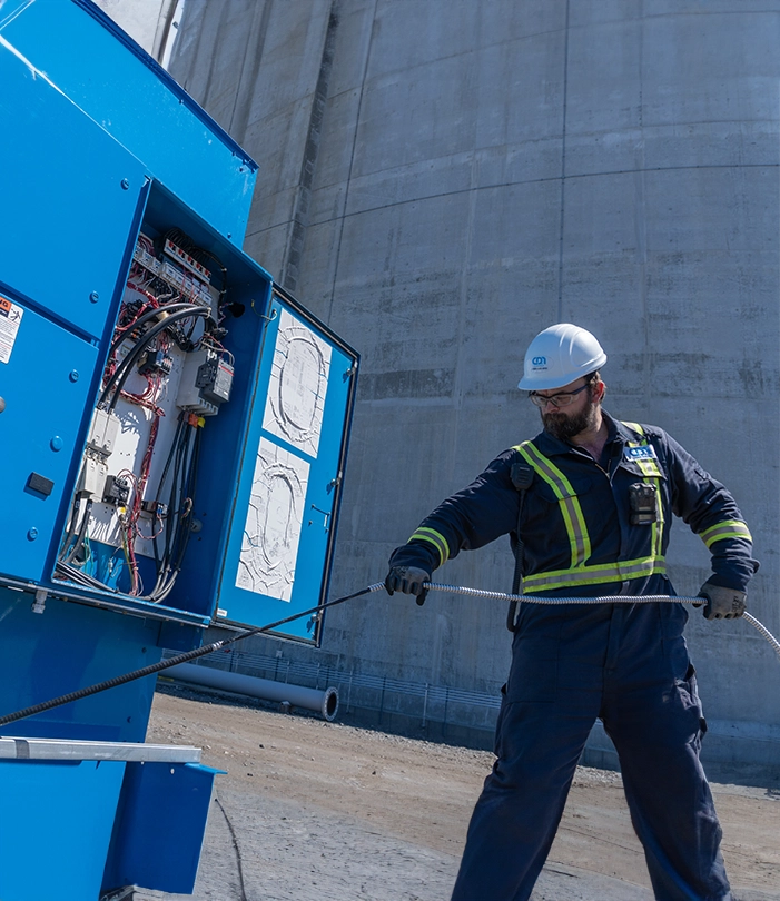 Worker in coveralls extracting cables