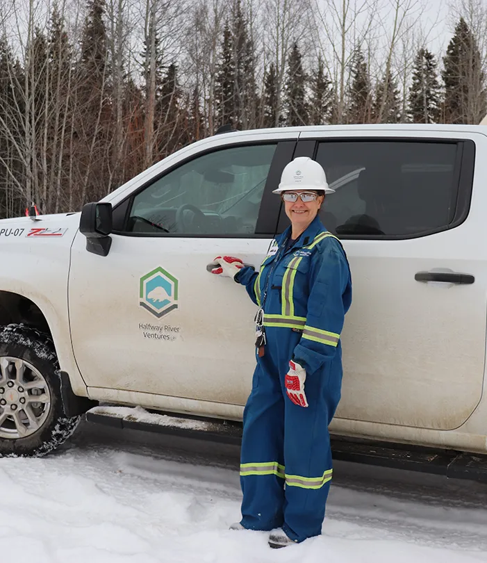 Anisa in coveralls with work truck