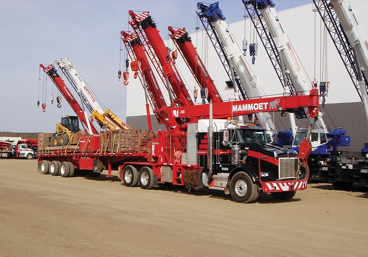 Loaded semi truck in front of several cranes